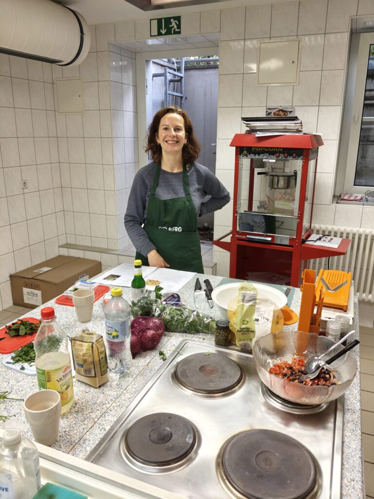 Alles nur Salat: Teilnehmerin am Herd mit vorbereiteten Zutaten in der Lehrküche