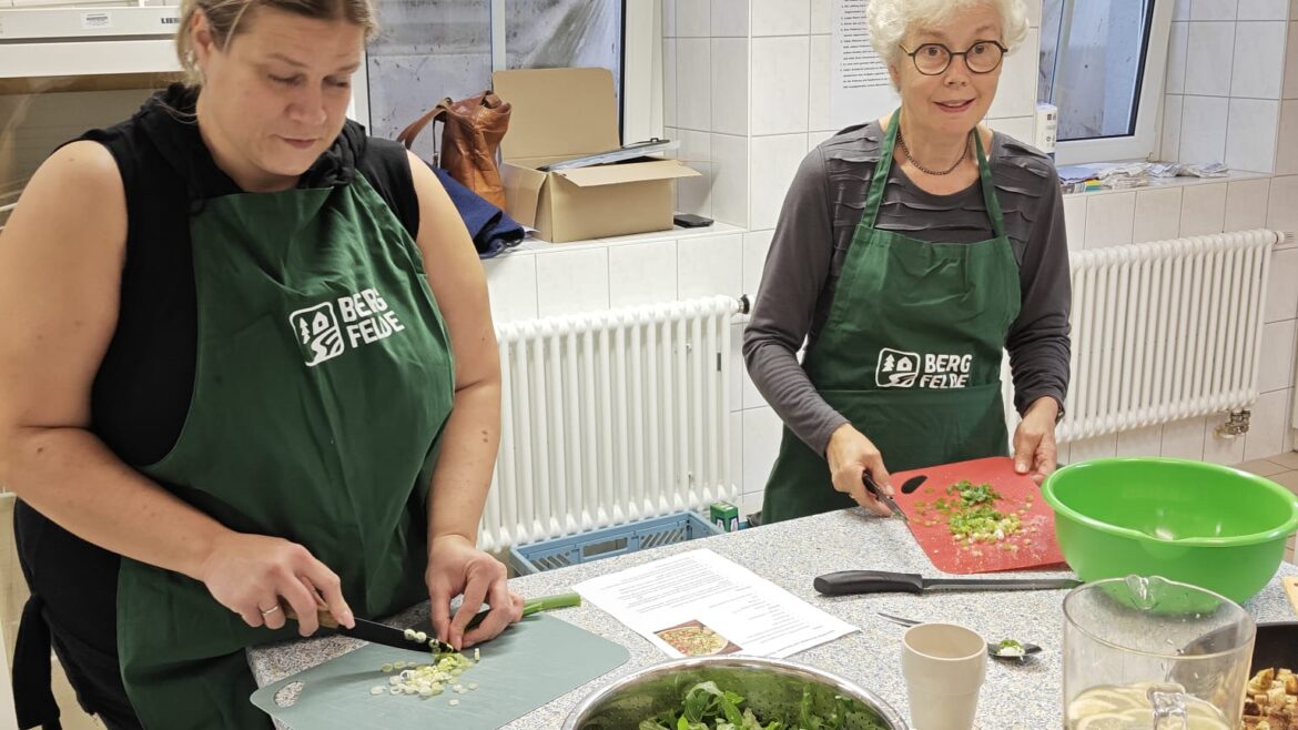 Alles nur Salat: zwei Teilnehmerinnen schneiden Gemüse und Kräuter an der Arbeitsfläche