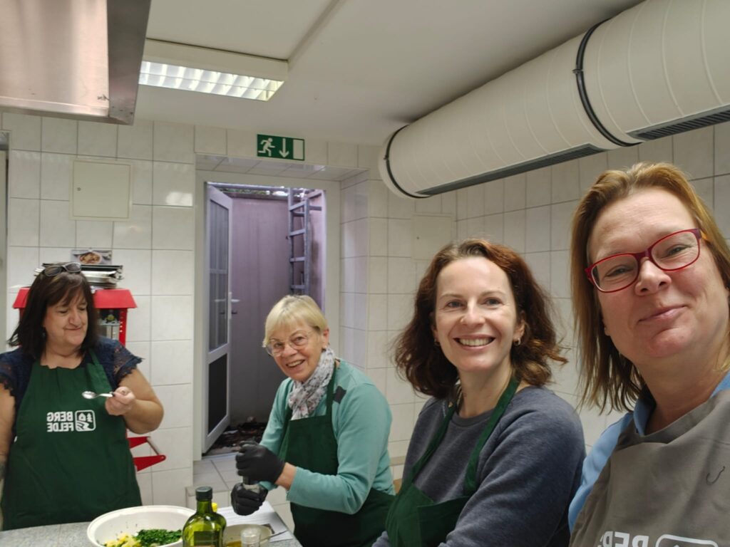 Alles nur Salat: vier Teilnehmerinnen in Bergfelde-Schürzen in der Lehrküche der Ahorngrundschule