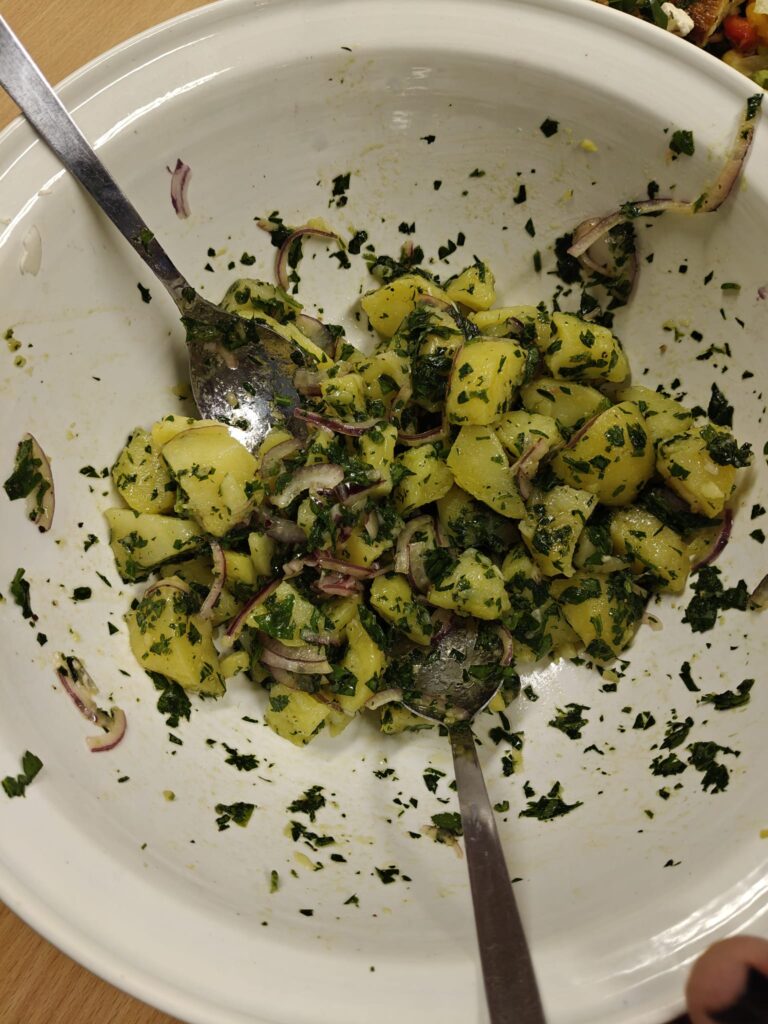 Alles nur Salat: Kartoffelsalat mit frischen Kräutern und roten Zwiebeln in einer Schüssel