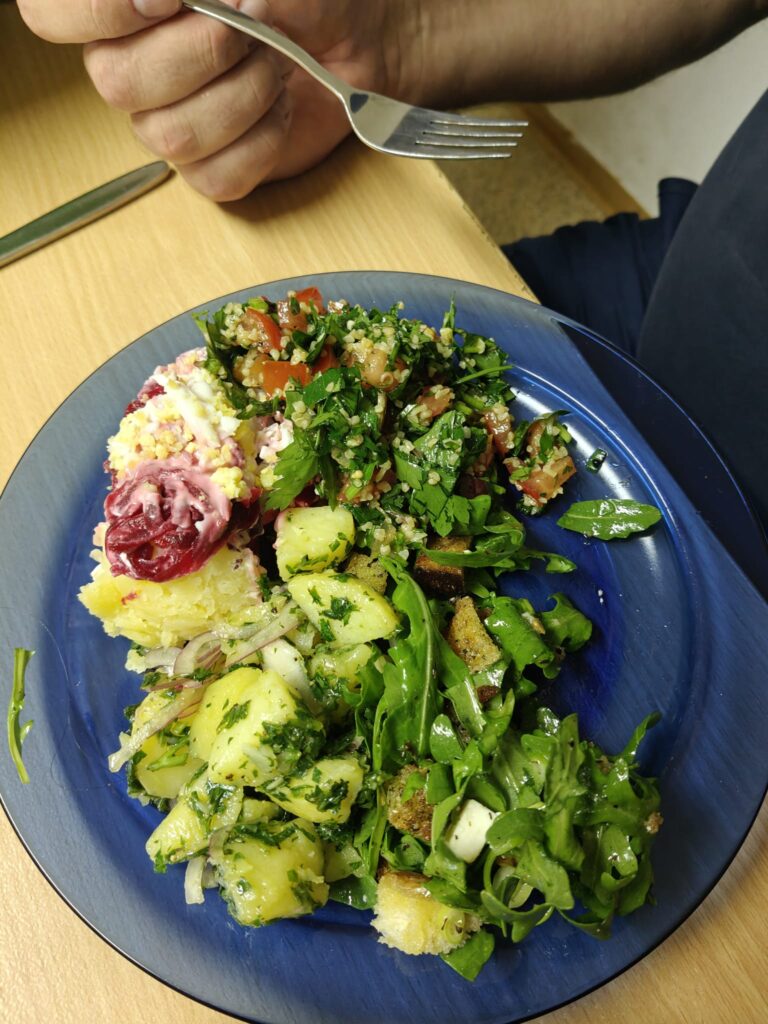 Alles nur Salat: gefüllter Teller mit Kartoffelsalat, Rucola und Kräutersalat bei der gemeinsamen Verkostung