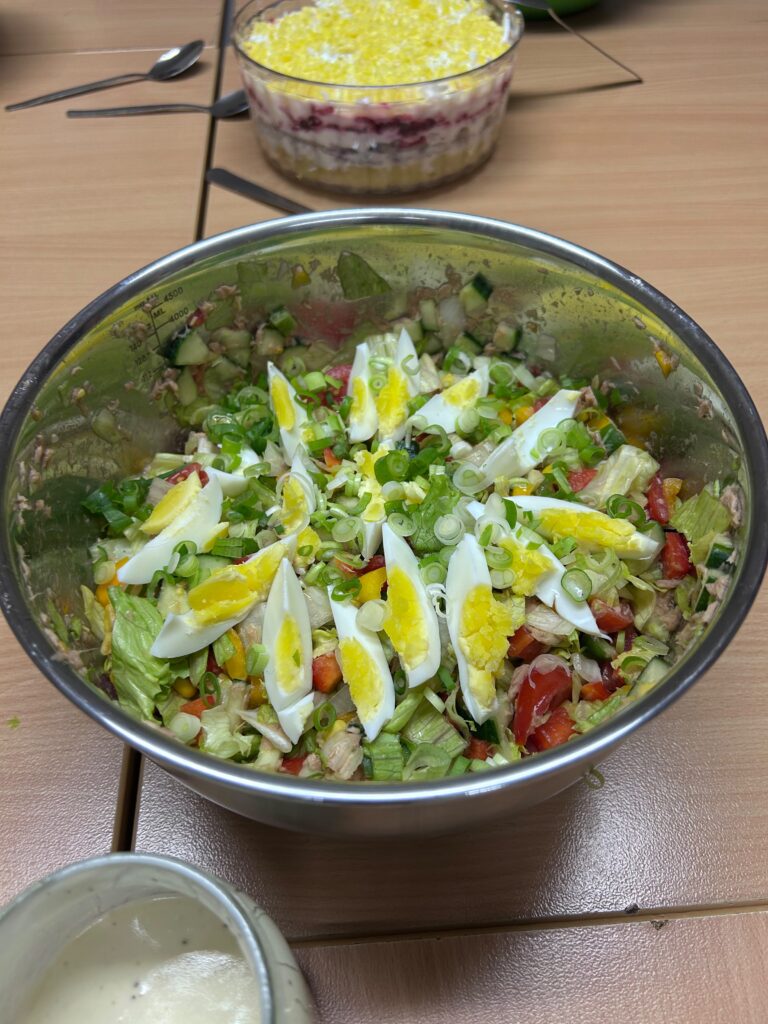 Alles nur Salat: große Schüssel mit buntem Salat und Eiern, dahinter ein Schichtsalat